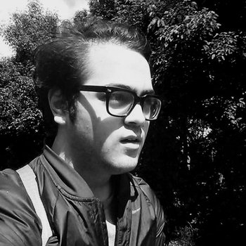 Chris is wearing glasses and looking off into distance outside with a focused facial expression
