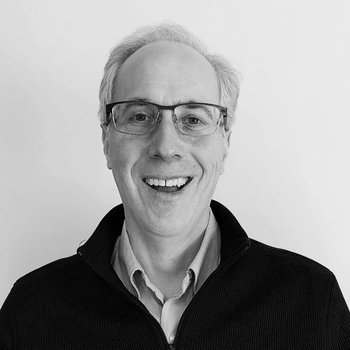 black and white image of David smiling with glasses on